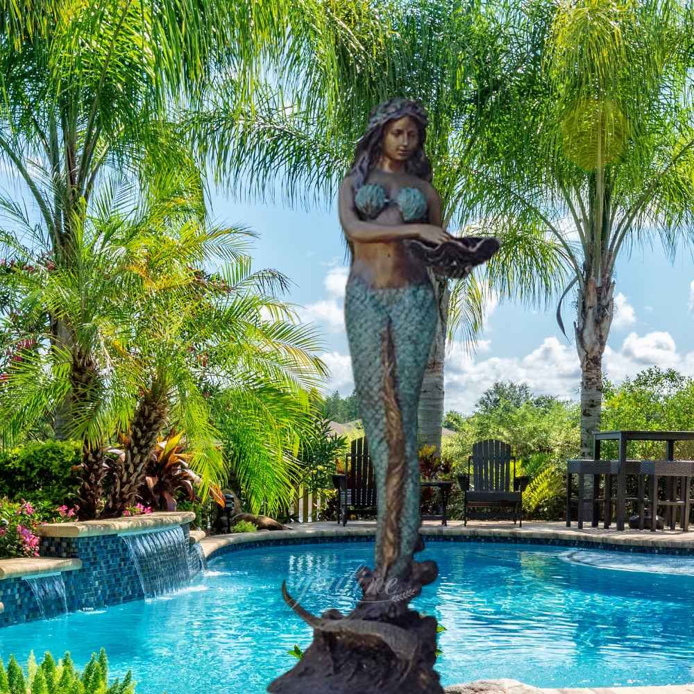 bronze mermaid with a garland on her head fountain